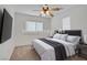 Staged bedroom with a neatly made bed, side tables, and a TV, creating a comfortable and inviting space at 6625 Pine Siskin Pl, North Las Vegas, NV 89084