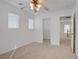 Clean and spacious bedroom with neutral carpet, a ceiling fan, and two windows, offering a versatile living space at 6625 Pine Siskin Pl, North Las Vegas, NV 89084