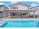 Charming backyard patio area featuring a covered patio, an outdoor kitchen, and a sparkling pool with spa at 6643 Tangled Vines Ave, Las Vegas, NV 89139