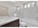 Bathroom with marble countertops, a tub, and shower combination with white tiling at 6643 Tangled Vines Ave, Las Vegas, NV 89139