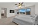 Primary bedroom with large windows, ceiling fan, and neutral decor at 6643 Tangled Vines Ave, Las Vegas, NV 89139