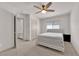 Minimalist bedroom with a gray upholstered bed, ceiling fan, and closet/storage area at 6643 Tangled Vines Ave, Las Vegas, NV 89139