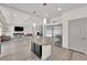 Modern kitchen with a large island, stainless steel refrigerator, and seamless flow into the living area at 6643 Tangled Vines Ave, Las Vegas, NV 89139