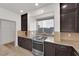 Modern kitchen features stainless steel appliances, granite countertops, and dark wood cabinetry at 6643 Tangled Vines Ave, Las Vegas, NV 89139