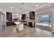 Modern kitchen featuring stainless steel appliances, dark cabinets, and a spacious island at 6643 Tangled Vines Ave, Las Vegas, NV 89139
