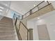 Staircase with carpeted steps, metal railing, and natural light from windows at 6643 Tangled Vines Ave, Las Vegas, NV 89139