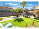 Lush backyard featuring a putting green, covered patio, and pool area perfect for entertaining or relaxing at 695 Orbiter Ln, Las Vegas, NV 89148