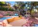 Backyard oasis with spa, seating area, mature landscaping, and pavers create a relaxing outdoor retreat at 695 Orbiter Ln, Las Vegas, NV 89148