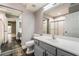 Bright bathroom with gray vanity, white countertop, and tiled shower reflected in the large mirror at 695 Orbiter Ln, Las Vegas, NV 89148