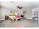 Spacious bedroom includes carpet, ceiling fan, and colorful bedspread with plenty of natural light at 695 Orbiter Ln, Las Vegas, NV 89148