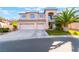Inviting two-story home with a spacious driveway and a lush green lawn at 695 Orbiter Ln, Las Vegas, NV 89148
