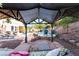 Relaxing gazebo area featuring comfortable seating, overlooking the pool and lush landscaping of the backyard retreat at 695 Orbiter Ln, Las Vegas, NV 89148