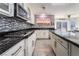 Modern kitchen featuring white cabinetry, granite countertops, mosaic backsplash, and stainless steel appliances at 695 Orbiter Ln, Las Vegas, NV 89148