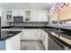 Modern kitchen featuring white cabinetry, granite countertops, mosaic backsplash, and stainless steel appliances at 695 Orbiter Ln, Las Vegas, NV 89148