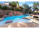 Sparkling pool with a rock waterfall feature, surrounded by lush landscaping and a cozy gazebo seating area at 695 Orbiter Ln, Las Vegas, NV 89148