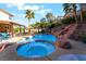 Incredible backyard pool and spa with rock waterfall, lush landscaping, and an outdoor dining area for luxurious outdoor living at 695 Orbiter Ln, Las Vegas, NV 89148