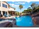 Expansive backyard pool and spa featuring rock accents and a waterfall, creating a luxurious outdoor oasis at 695 Orbiter Ln, Las Vegas, NV 89148