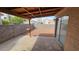 Private back patio area with gravel landscaping, mature trees, and a covered area at 7053 Magic Moment Ln, Las Vegas, NV 89119
