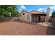 Large, private backyard with a covered patio and low-maintenance gravel landscaping surrounded by a block wall at 7053 Magic Moment Ln, Las Vegas, NV 89119
