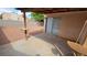 A covered backyard patio features a desert rock landscape and a high block wall for privacy at 7053 Magic Moment Ln, Las Vegas, NV 89119