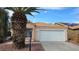 Charming single-story home with a two-car garage and a well-maintained front yard with gravel and mature palm tree at 7053 Magic Moment Ln, Las Vegas, NV 89119