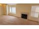 Bright living room featuring neutral carpet, a cozy fireplace, and plenty of natural light at 7053 Magic Moment Ln, Las Vegas, NV 89119