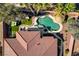 Aerial view of a backyard featuring a pool, tiki hut, lawn, and lush landscaping at 7204 Royal Melbourne Dr, Las Vegas, NV 89131