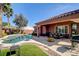 Lush backyard showcasing a pool, covered patio, and cozy dining set at 7204 Royal Melbourne Dr, Las Vegas, NV 89131