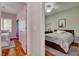 Cozy bedroom boasts wood floors and a comfortable bed; adjacent to a second bedroom at 7204 Royal Melbourne Dr, Las Vegas, NV 89131