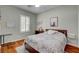 Inviting bedroom with wood floors, plantation shutters, and a soft rug at 7204 Royal Melbourne Dr, Las Vegas, NV 89131