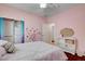 Bright bedroom features a ceiling fan, patterned bedding, and a closet with mirrored doors at 7204 Royal Melbourne Dr, Las Vegas, NV 89131