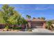 Charming single-story home featuring a tile roof, landscaped yard, and a two-car garage, set against a backdrop of a bright blue sky at 7204 Royal Melbourne Dr, Las Vegas, NV 89131
