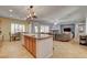 Open-concept kitchen with an island, pendant lighting, and modern appliances, seamlessly connected to the living area at 7204 Royal Melbourne Dr, Las Vegas, NV 89131