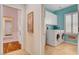 Well-organized laundry room with cabinetry, modern machines, and bright blue walls at 7204 Royal Melbourne Dr, Las Vegas, NV 89131