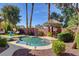 Private backyard pool with a tiki hut and lounge area, creating a relaxing outdoor oasis at 7204 Royal Melbourne Dr, Las Vegas, NV 89131