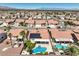 An aerial view of a desert community featuring terra cotta roofs, desert landscaping, and private pools at 7489 Crystal Clear Ave, Las Vegas, NV 89113