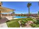 Backyard with lush landscaping, a pool, and a covered patio for relaxing and entertaining at 7489 Crystal Clear Ave, Las Vegas, NV 89113