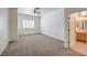 Spacious bedroom with neutral carpet, ceiling fan and window with white shutter at 7489 Crystal Clear Ave, Las Vegas, NV 89113