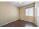 A cozy bedroom with hardwood floors, a ceiling fan, and bright natural light from the shuttered window at 7489 Crystal Clear Ave, Las Vegas, NV 89113