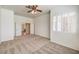 Spacious carpeted bedroom with ceiling fan and shuttered window showing entry to hall at 7489 Crystal Clear Ave, Las Vegas, NV 89113