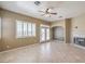 Spacious living room with a fireplace, ceiling fan, tile floors and access to the backyard through french doors at 7489 Crystal Clear Ave, Las Vegas, NV 89113