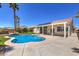 A backyard oasis with a pool, outdoor kitchen area, and mature palm trees at 7489 Crystal Clear Ave, Las Vegas, NV 89113
