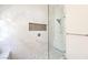 Close-up of walk-in shower featuring marble tile, shower niche and glass door at 7489 Crystal Clear Ave, Las Vegas, NV 89113