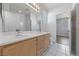 Well-lit bathroom featuring double sinks, large mirror, and tile floor at 7589 Grassy Bank St, Las Vegas, NV 89139
