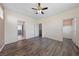 This bright bedroom features wood floors, a ceiling fan, and easy access to the bathroom at 7589 Grassy Bank St, Las Vegas, NV 89139