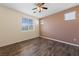 This bedroom features beautiful wood floors, large windows, and a ceiling fan at 7589 Grassy Bank St, Las Vegas, NV 89139