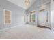 Bright living room featuring a vaulted ceiling, large windows, and neutral carpet at 7589 Grassy Bank St, Las Vegas, NV 89139
