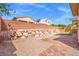 A lovely backyard with a brick patio, rock wall, and easy-care desert landscaping for relaxed outdoor living at 7931 Campers Village Ave, Las Vegas, NV 89178