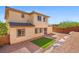 Exterior shot of the home's backyard, featuring artificial turf, a brick patio, and desert-friendly landscaping at 7931 Campers Village Ave, Las Vegas, NV 89178