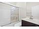 Bathroom with a tub-shower combination with glass doors and dark-stained cabinets at 7931 Campers Village Ave, Las Vegas, NV 89178